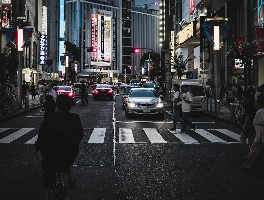 Flux de passants devant des commerces en pied d’immeuble à proximité d’une grande gare japonaise.