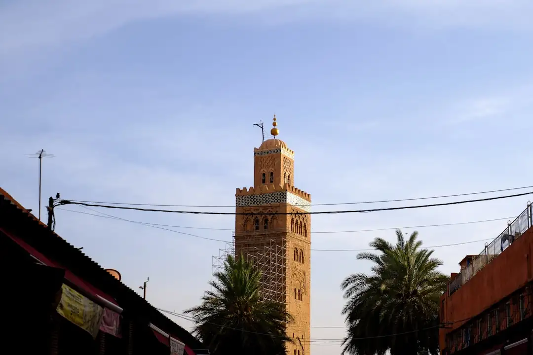 Acquéreur consultant des documents de propriété sur le balcon d’un appartement dans un quartier marocain.
