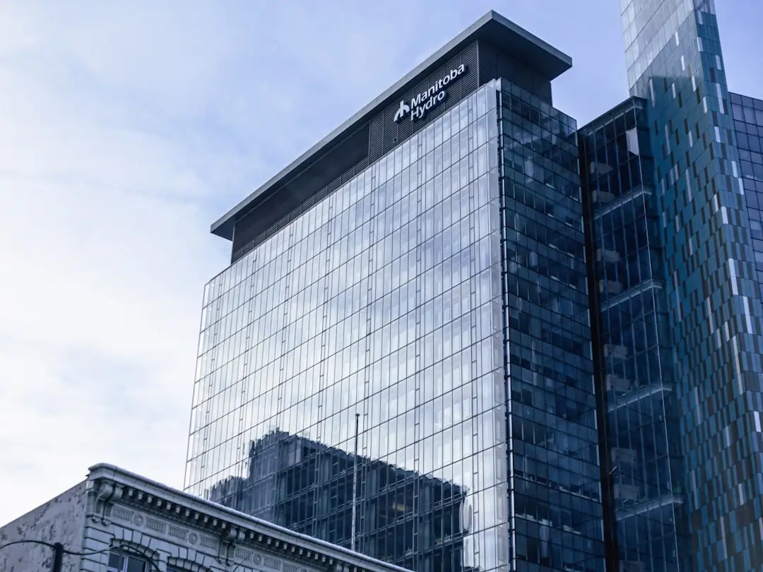 Dirigeant de dos examinant des documents financiers dans un bureau face à un quartier d’affaires américain.