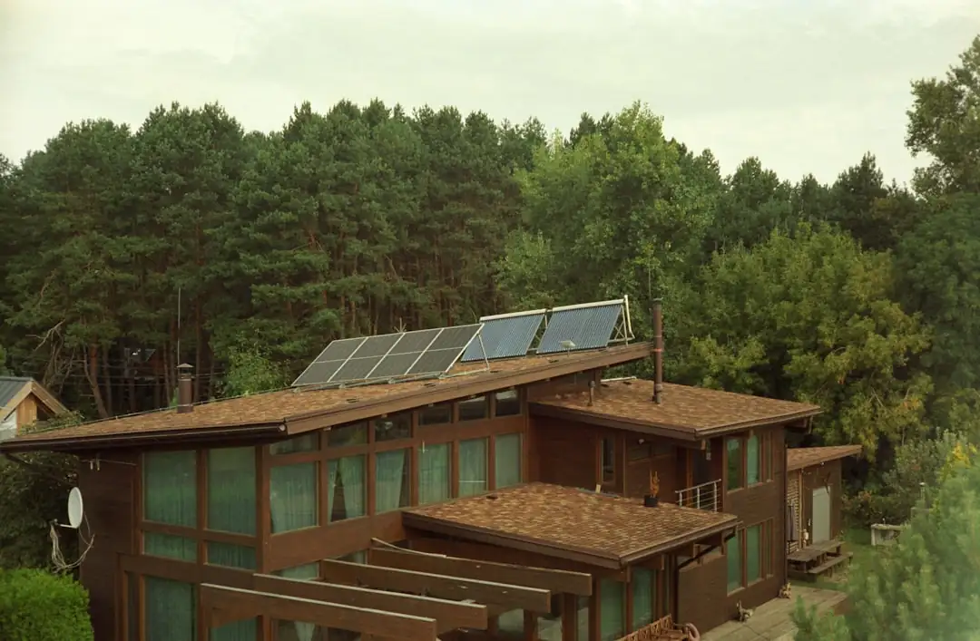 Rangées de panneaux photovoltaïques sur le toit d’un entrepôt et équipements électriques au premier plan.