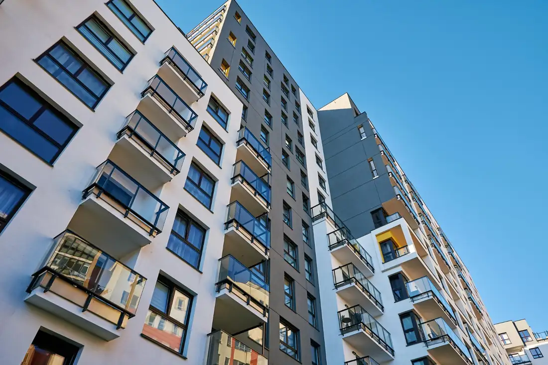 Immeubles récents et bâtiments anciens alignés dans un quartier résidentiel nantais, le long d’une rue arborée.