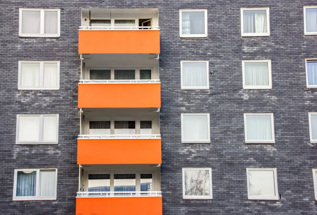 Rue résidentielle arborée d’une ville moyenne française, entre immeubles rénovés, maisons et piste cyclable.