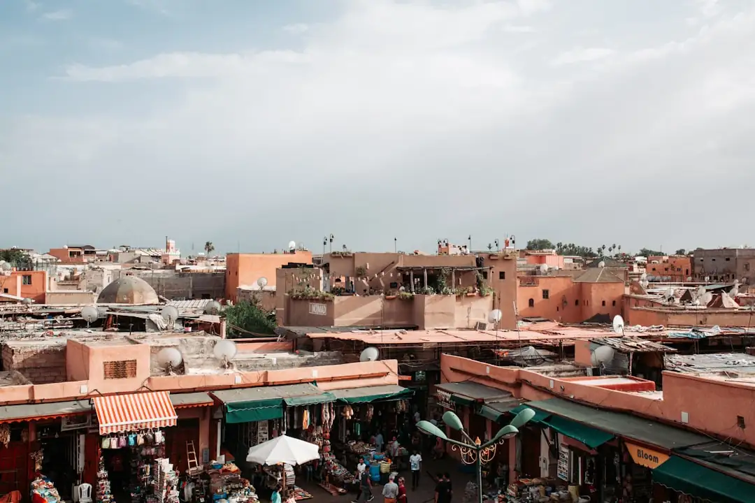 Rue résidentielle de Guéliz à Marrakech avec façades ocre, trottoirs arborés et immeubles contemporains.