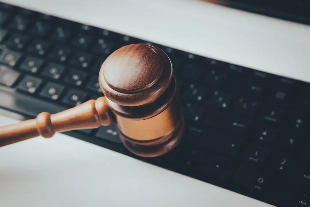 Écran d’ordinateur ouvert sur un espace fiscal, avec dossiers de location et clés d’appartement sur un bureau.