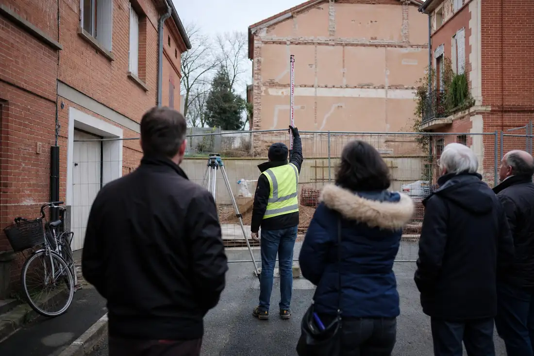 Rue étroite en impasse à Toulouse, bordée de maisons, devant un terrain préparé pour un projet résidentiel.