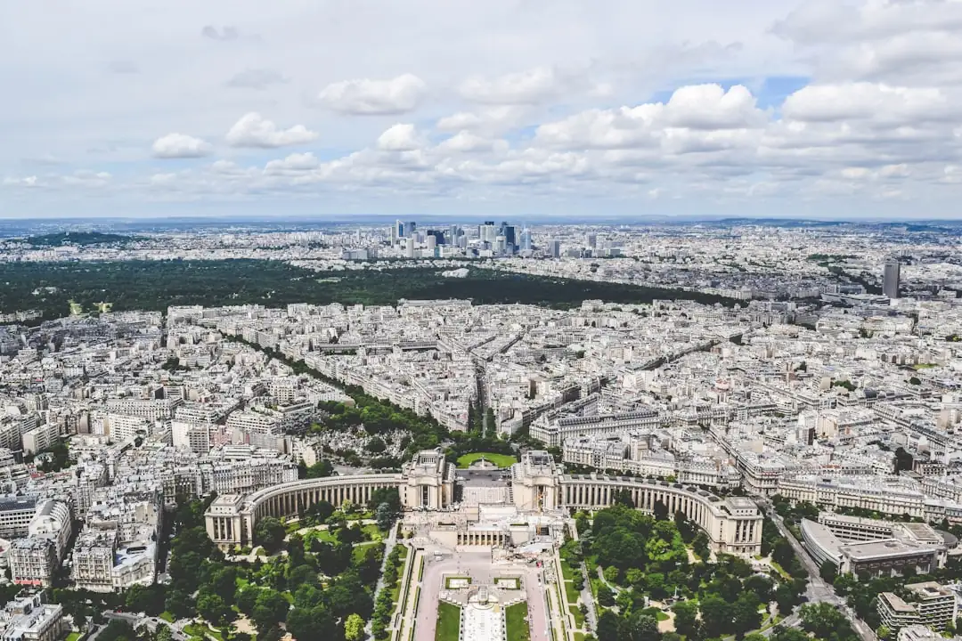 Couloir ancien d’un immeuble parisien où un acquéreur consulte un dossier avant la visite d’un petit lot.