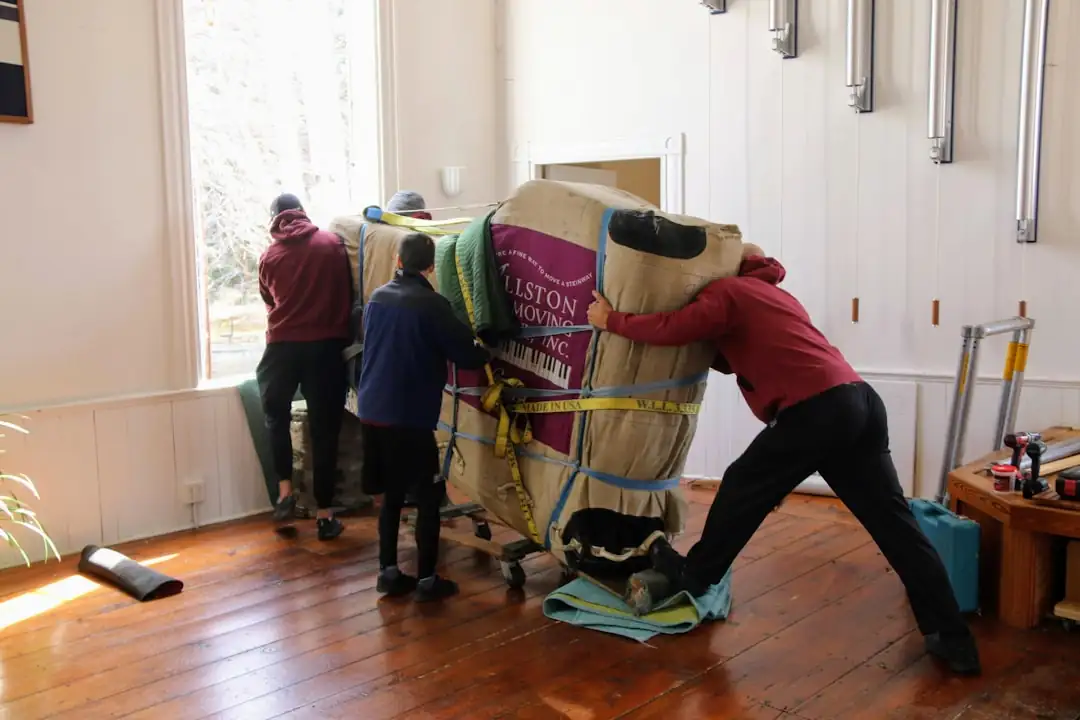 Couple préparant l’achat d’un nouveau logement avec dossiers, clés et cartons dans leur appartement.