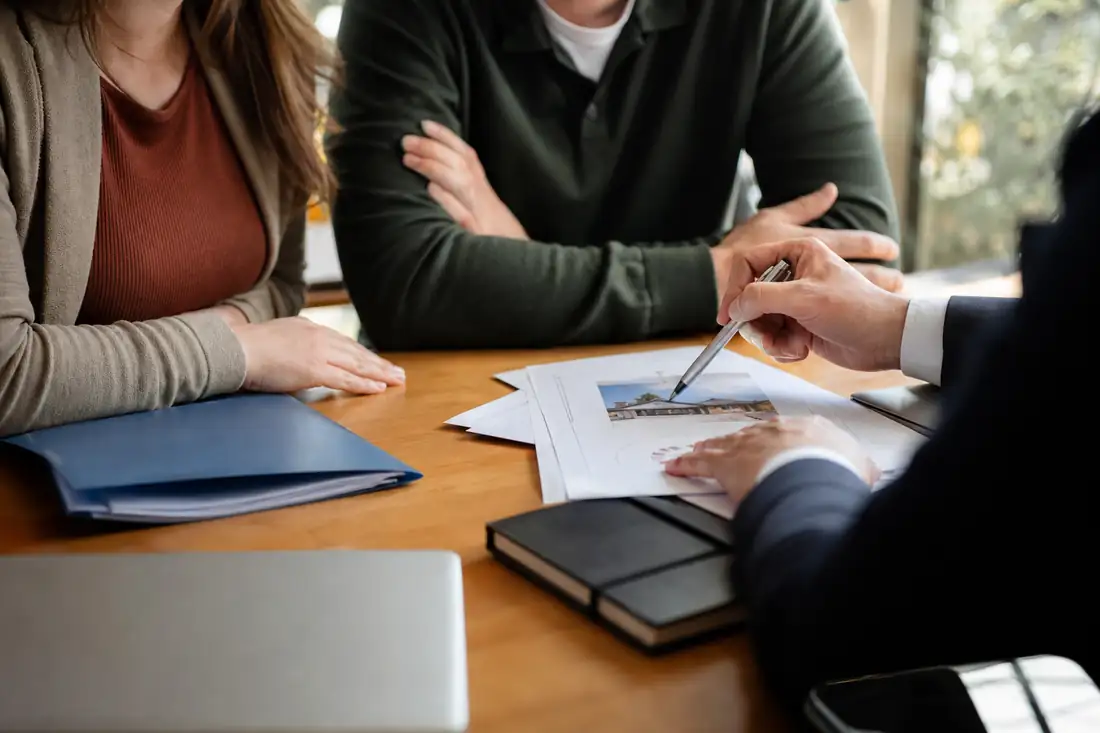 Couple consultant les conditions d'un prêt immobilier avec un conseiller bancaire
