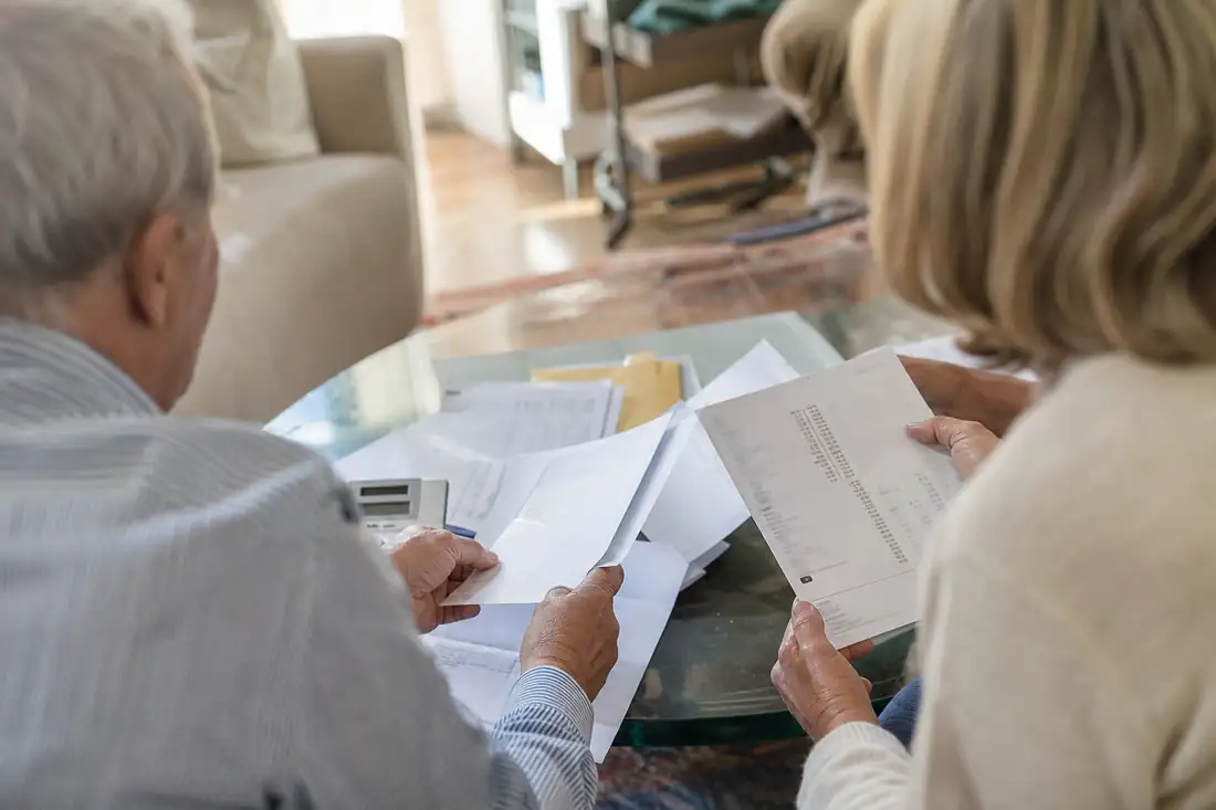 Couple senior examinant les documents d'un prêt garanti par leur logement