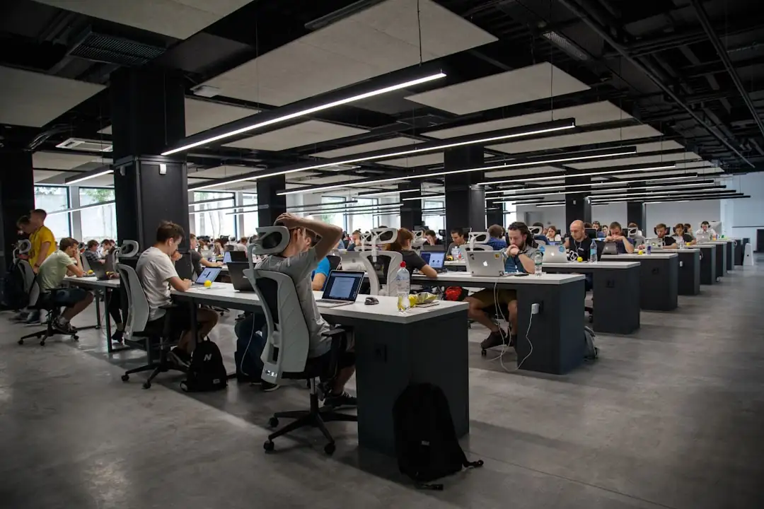 Tour de bureaux contemporaine à Bengaluru avec des salariés non identifiables dans un hall vitré lumineux.