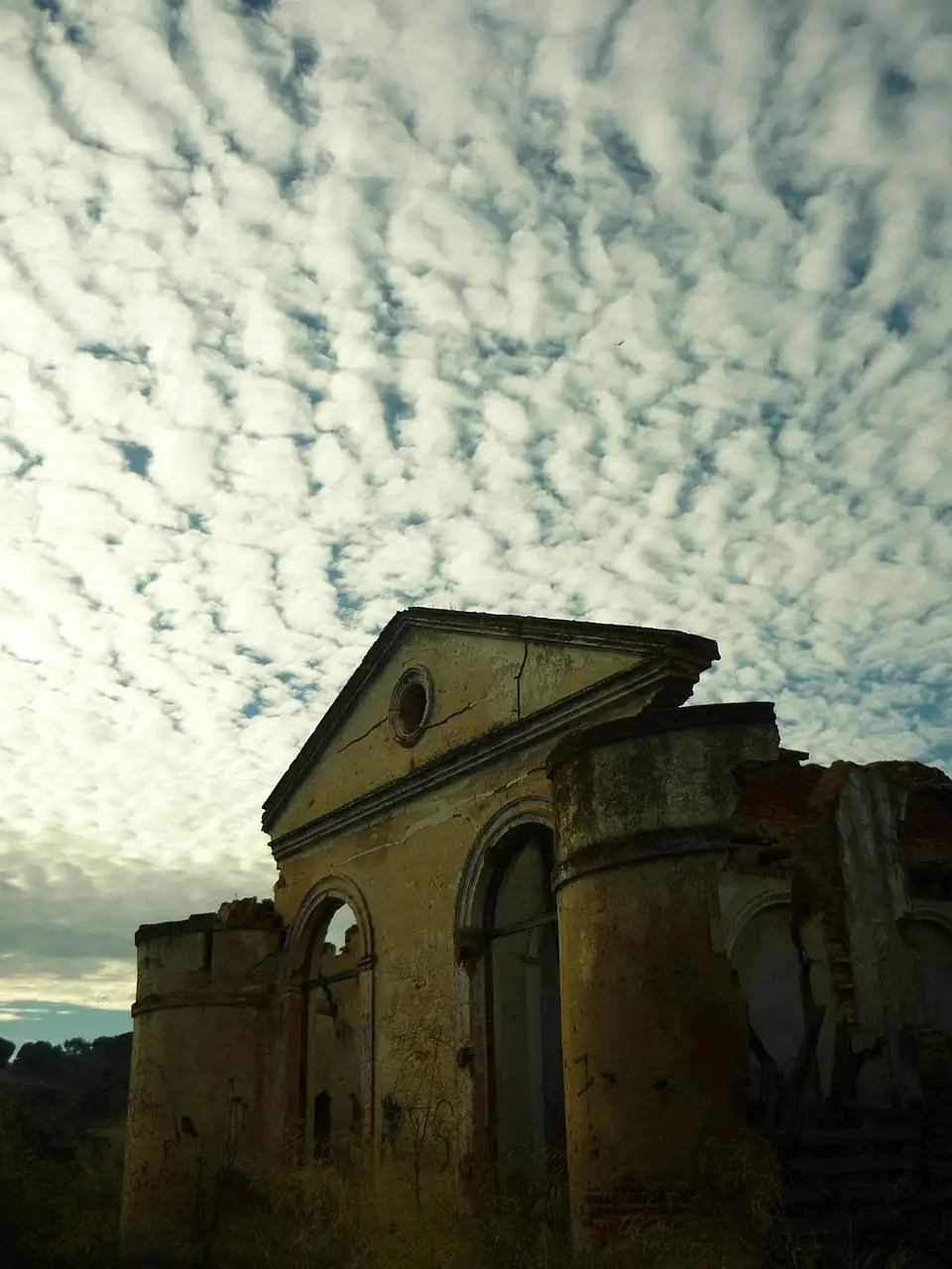 Acquéreur et architecte examinant les murs d’une maison en ruines avant un projet de rénovation.