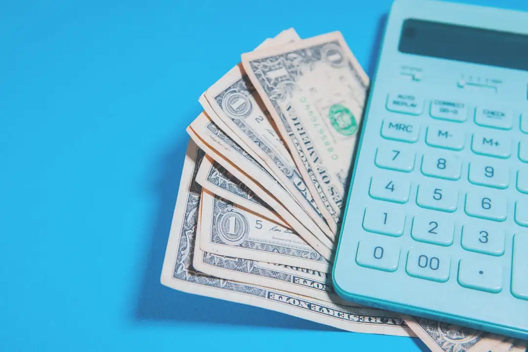 Calculatrice, clé et documents de financement posés sur une table lors de la préparation d’un achat immobilier.