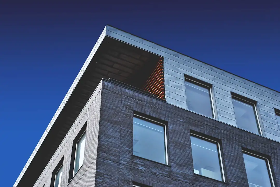 Investisseur préparant un budget locatif devant un immeuble résidentiel ancien dans un quartier urbain.