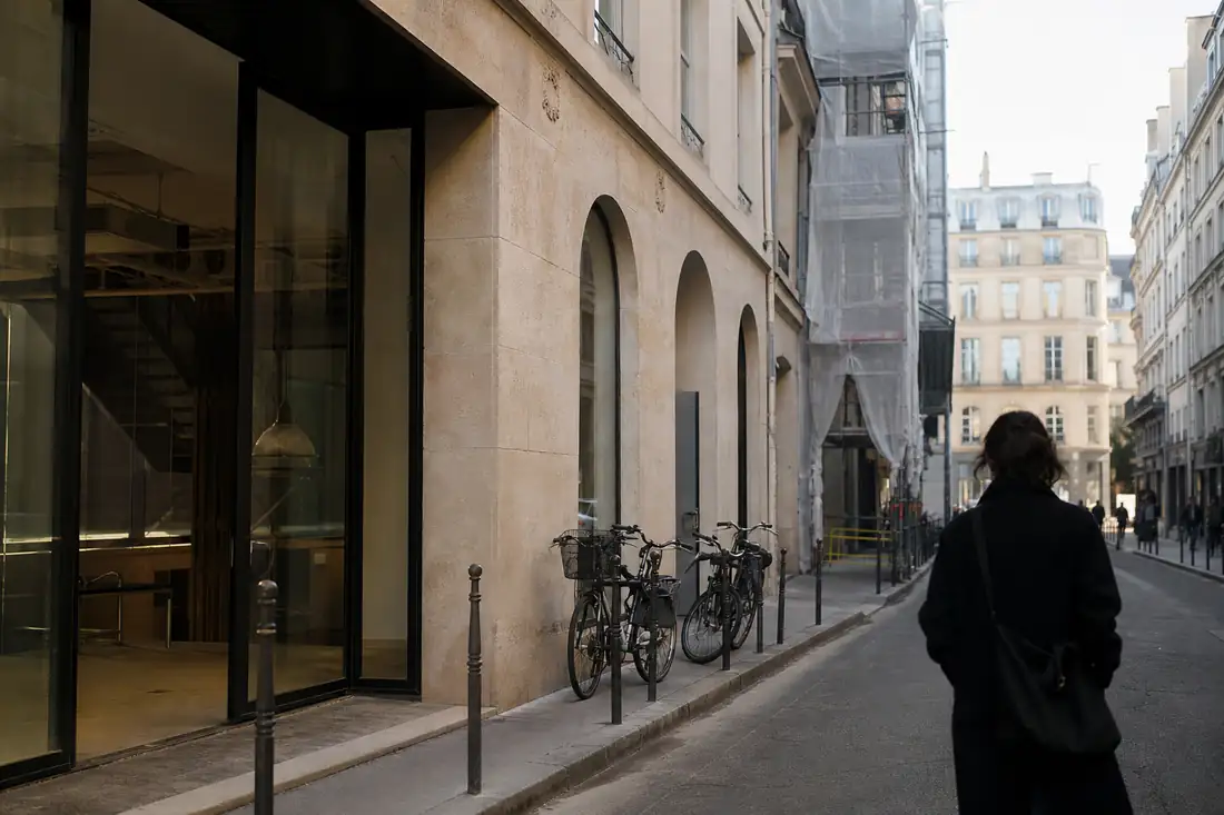 Immeuble de bureaux rénové dans le quartier du Sentier, avec façade parisienne et accès vélos discret.