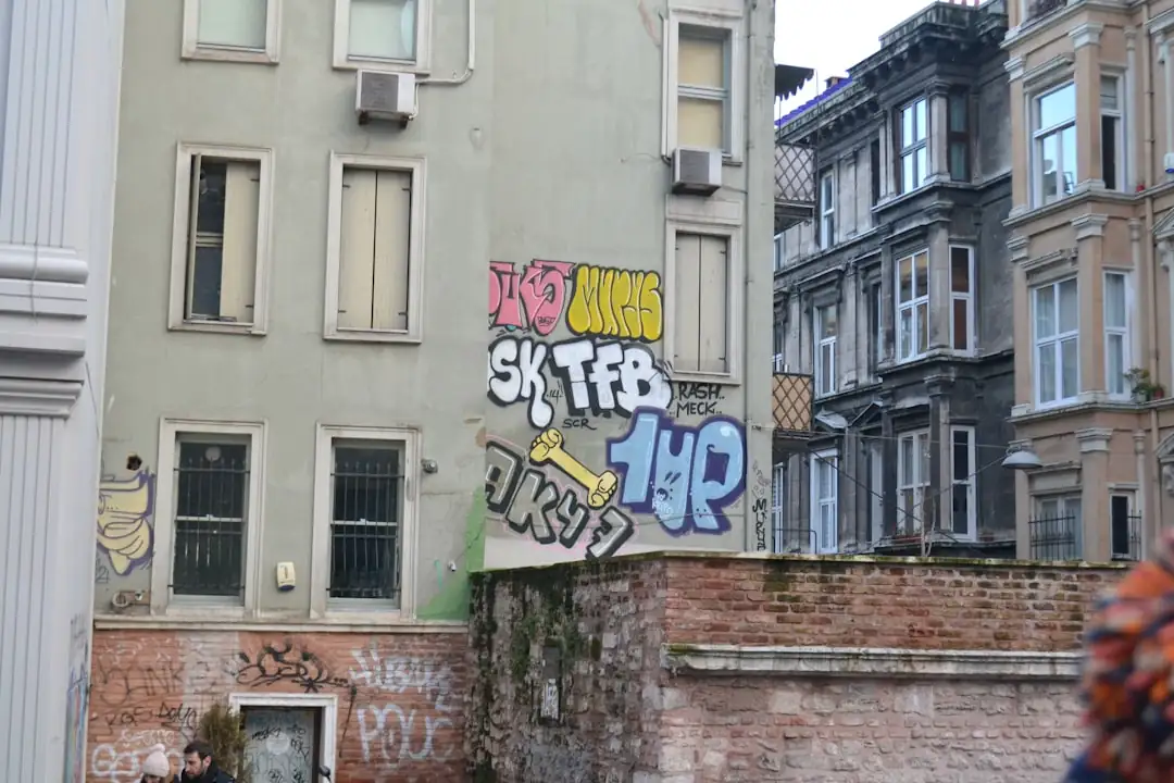 Analyste immobilier consultant des documents de marché devant une fenêtre donnant sur des immeubles urbains.
