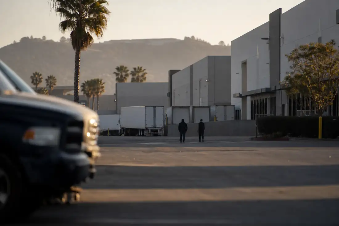 Entrepôts logistiques et quais de chargement dans une zone industrielle dense du sud de la Californie au matin.