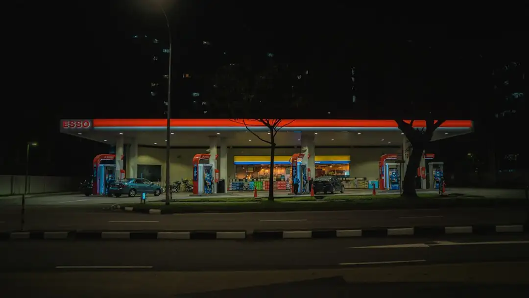 Station-service routière avec bornes de recharge, commerce de proximité et accès automobile en zone périurbaine.