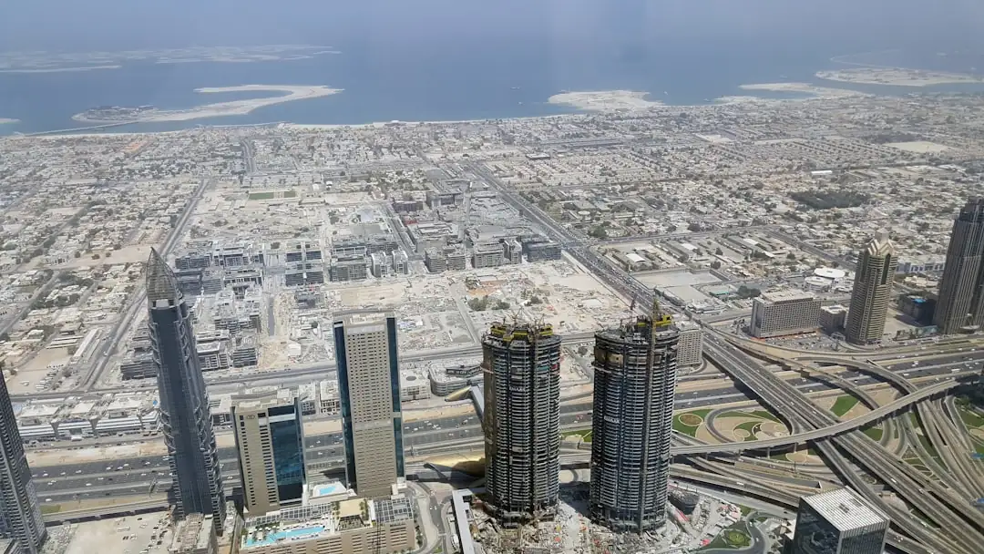 Quartier résidentiel moderne en construction en Arabie saoudite, avec immeubles livrés et grues en arrière-plan.
