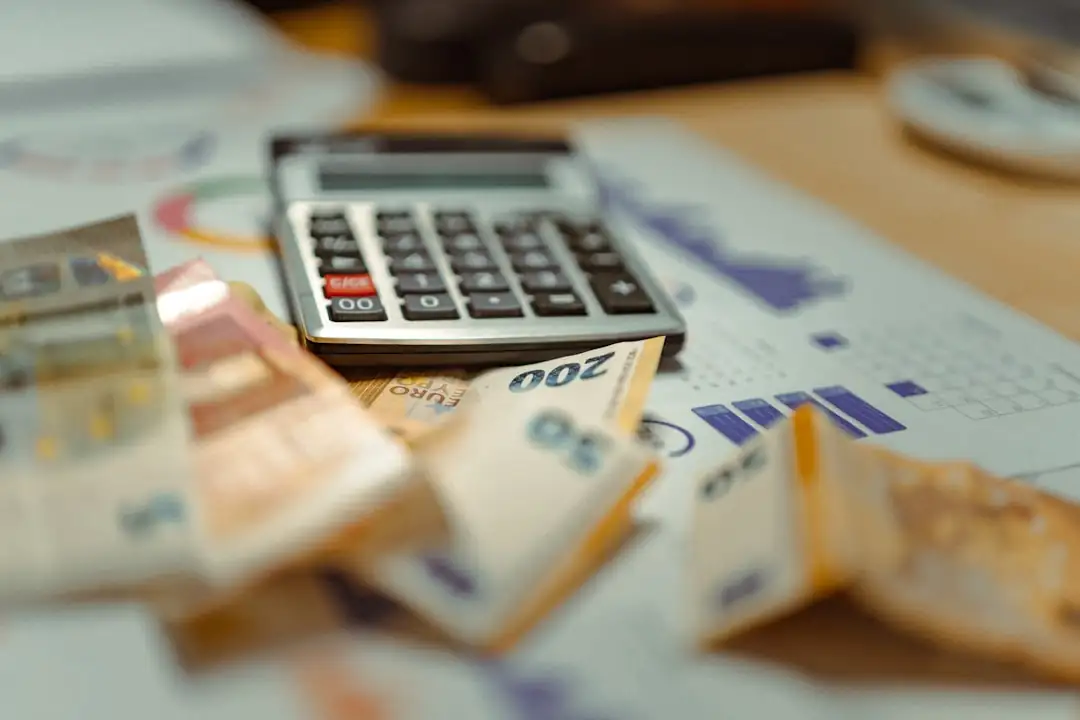 Dossier de financement immobilier étudié sur une table devant un immeuble tertiaire contemporain en ville.