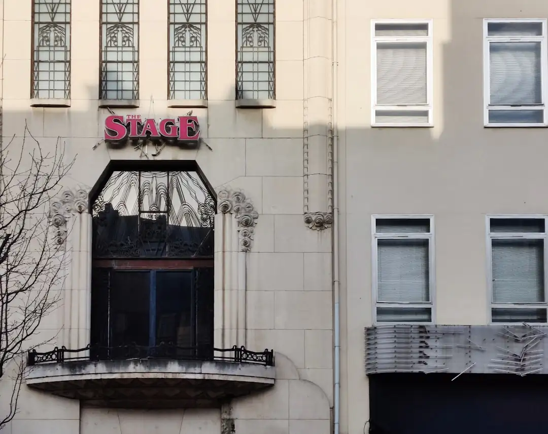 Devanture sobre d’une agence immobilière française avec conseillers flous à l’intérieur et annonces non lisibles.