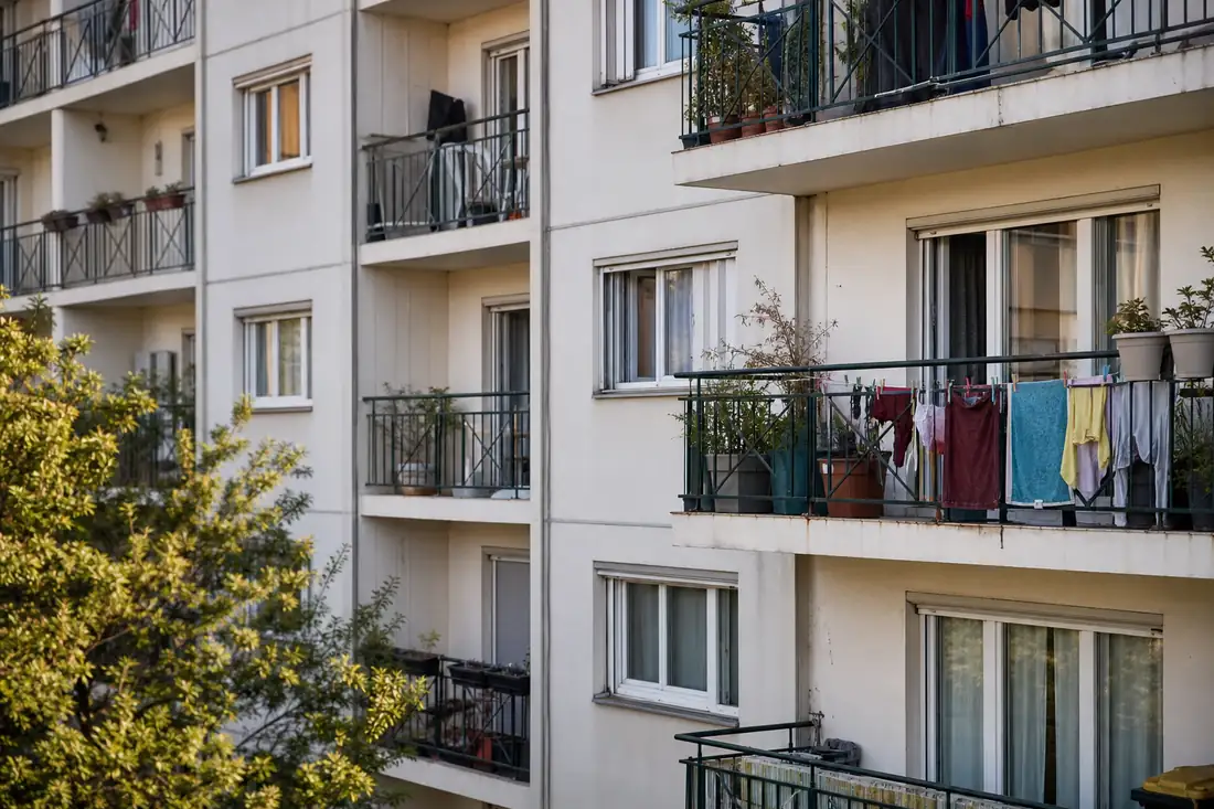 Façade d’un immeuble de logements sociaux avec balcons en fin d’après-midi