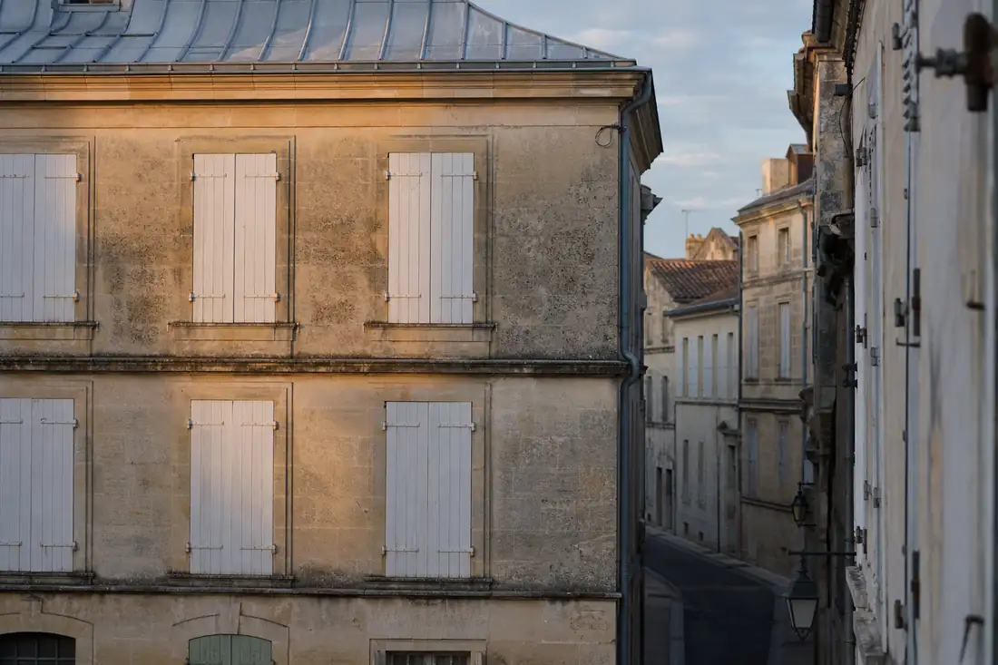 Façade d’un immeuble ancien aux volets clos dans une rue résidentielle française déserte