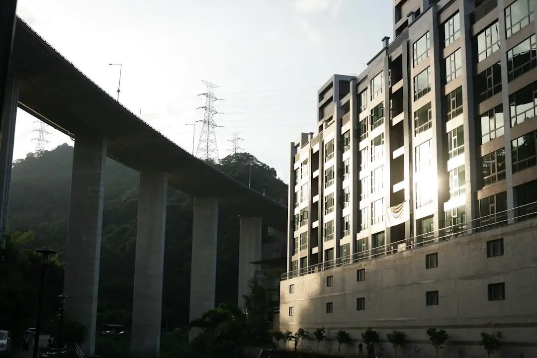 Investisseur examinant des documents de fonds immobilier devant un immeuble de bureaux en arrière-plan.
