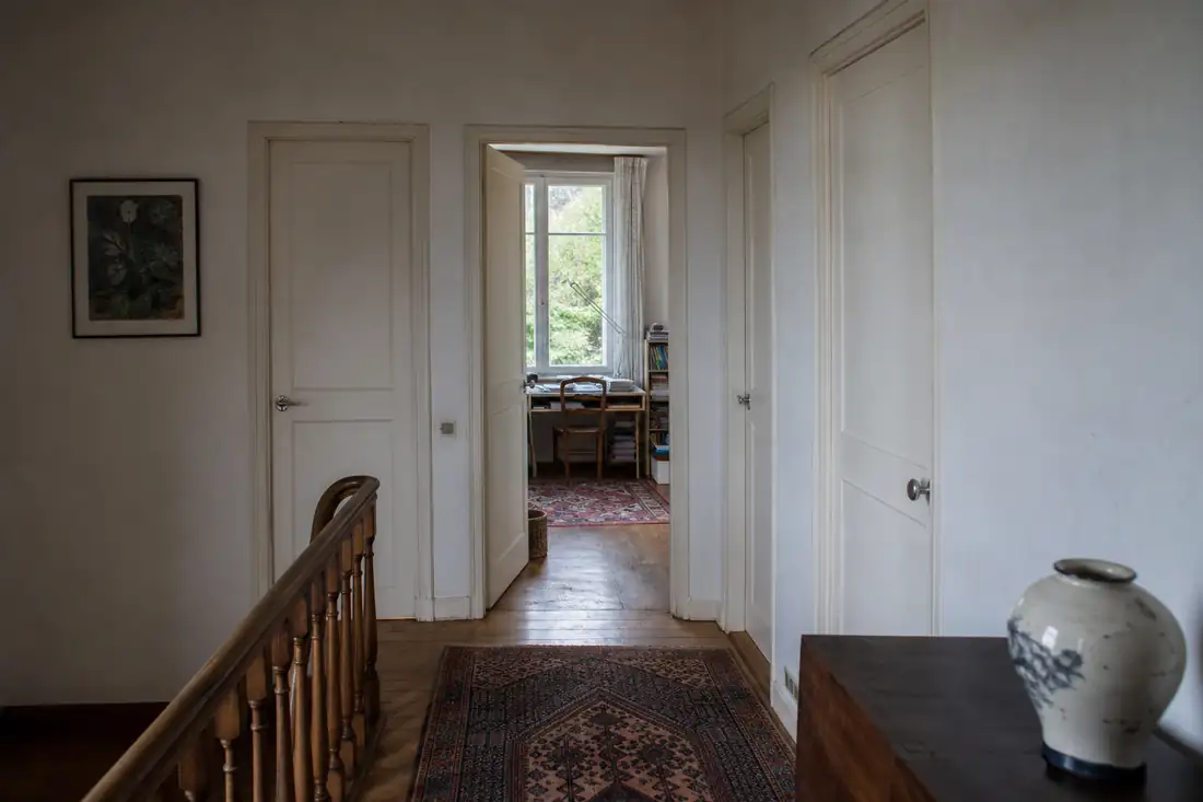 Intérieur d’une grande maison familiale française avec plusieurs pièces et un espace de travail aménagé.