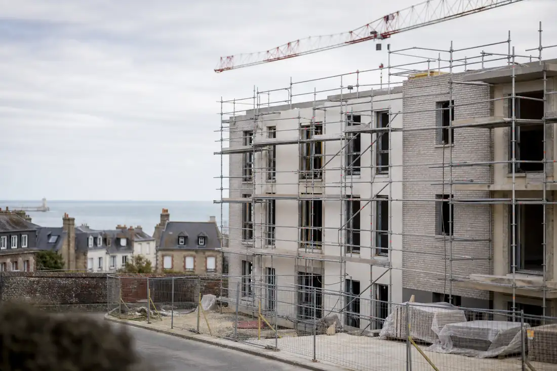 Résidence neuve en chantier dans un quartier côtier normand, avec façades claires et échafaudages.