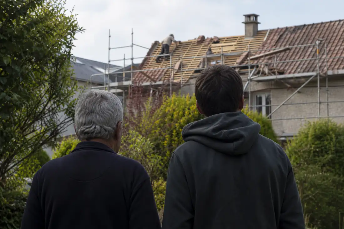 Toiture de maison en travaux de réfection observée depuis le jardin familial