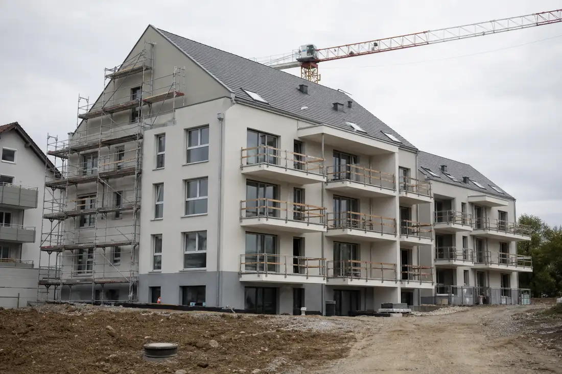 Immeuble résidentiel neuf en fin de chantier, façade achevée et balcons encore protégés
