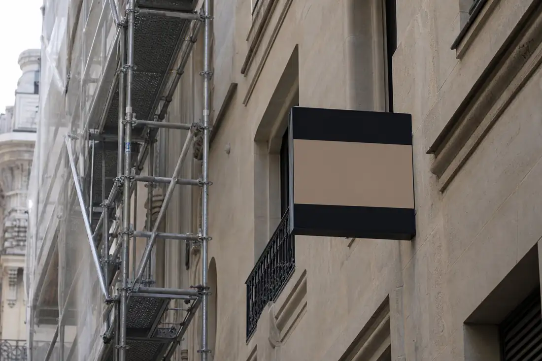 Immeuble en copropriété avec échafaudage de ravalement et panneau de vente d'un appartement